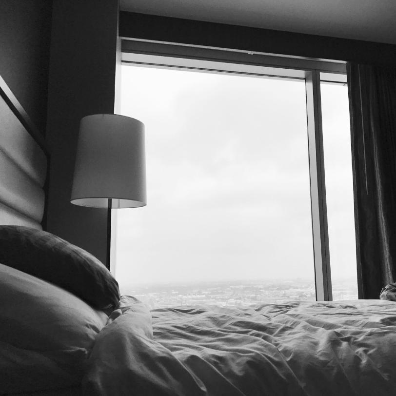 Bett mit Ausblick auf eine Großstadt